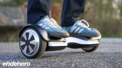 Rasmus standing on a hoverboard. Narrow focal length with focus on the right wheel and the rest fading out of focus