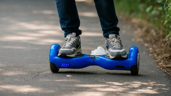 Man riding a blue hoverboard on an asphalt road