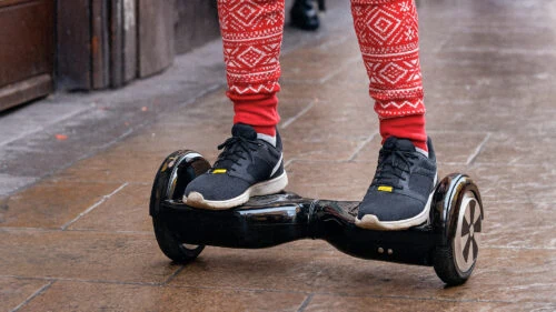 Woman riding on a hoverboard on the pavement in the UK