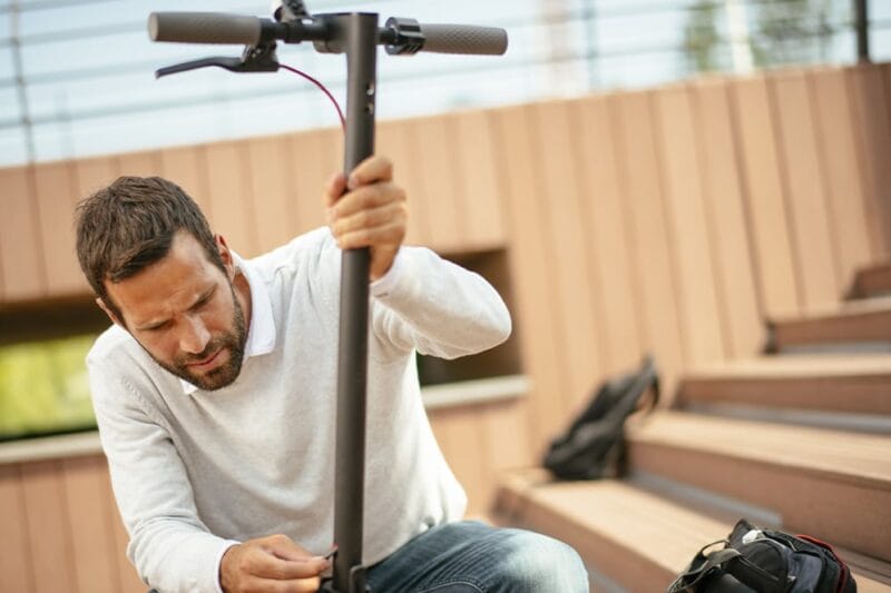 man repairing his electric scooter