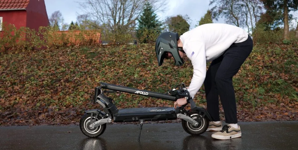 Folding down the Apollo Phantom electric scooter