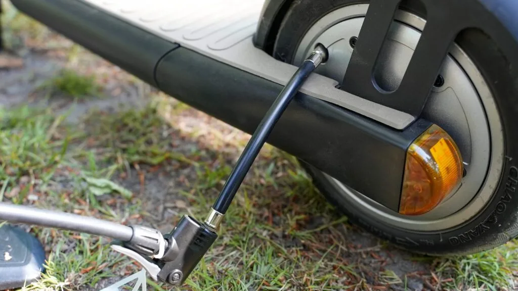 Close-up of a valve extender connected to an electric scooter tire