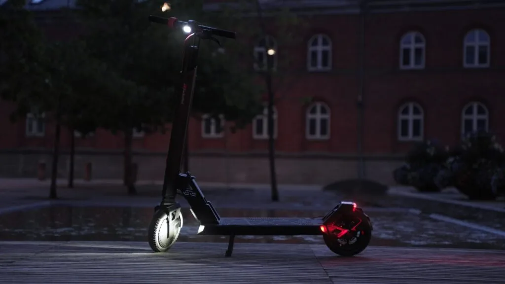 Turboant V8 electric scooter at night with lights turned on