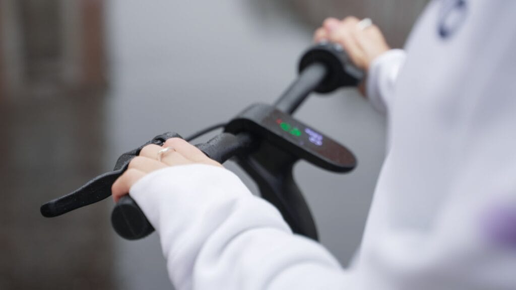 Girl braking on an electric scooter in the rain