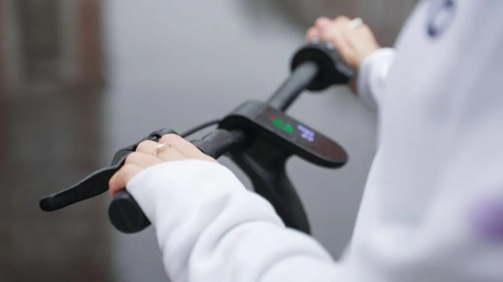 Girl braking on an electric scooter in the rain