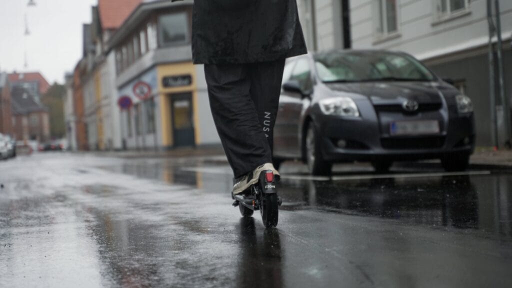 Girl riding through the rain on an electric scooter