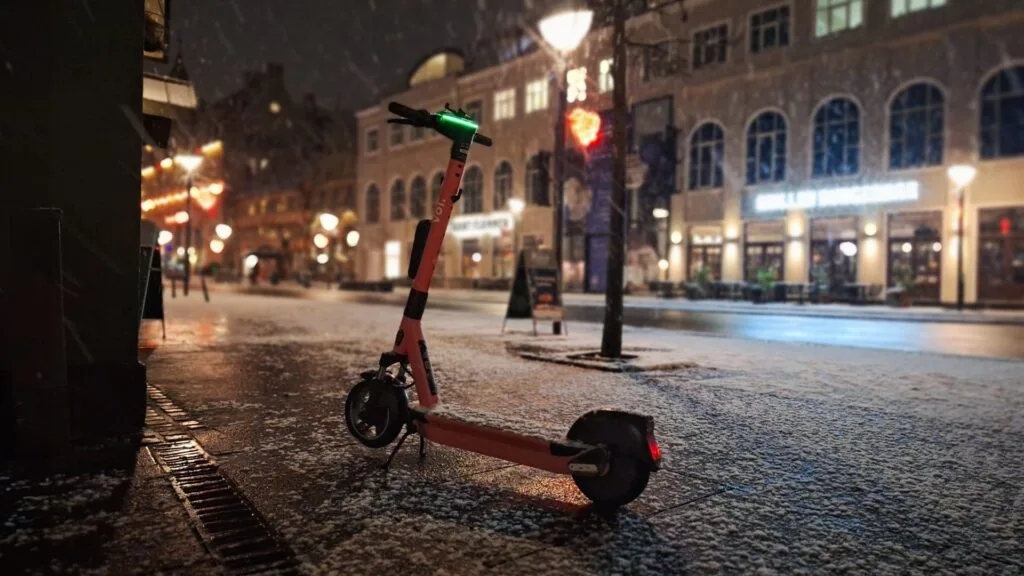 Rental e-scooter in the snow during winter with snow in a cozy Christmas setting in the city at night