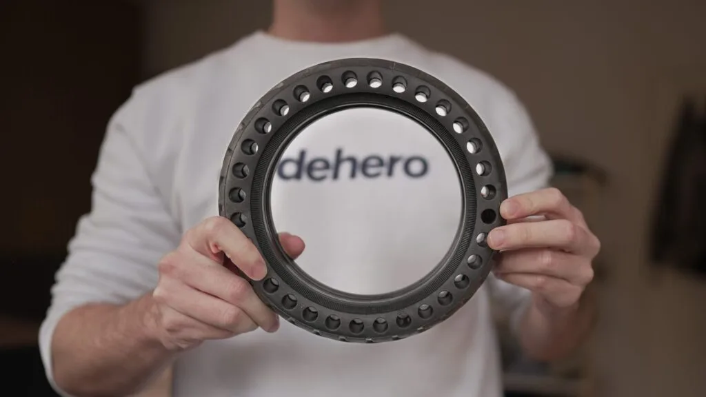 Man holding a honeycomb solid tire for an electric scooter wearing an ERideHero shirt