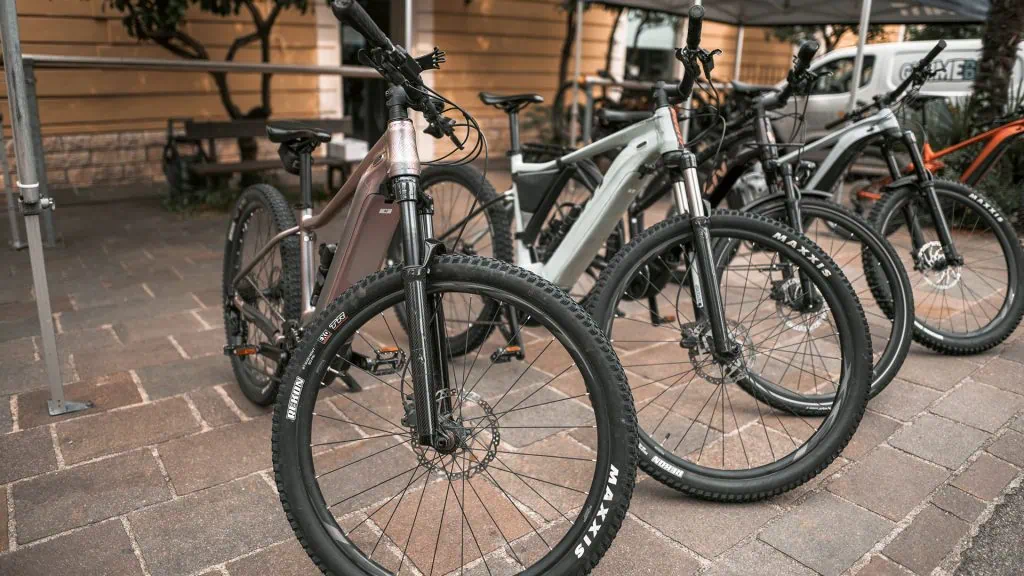 A row of electric bikes on a sidewalk